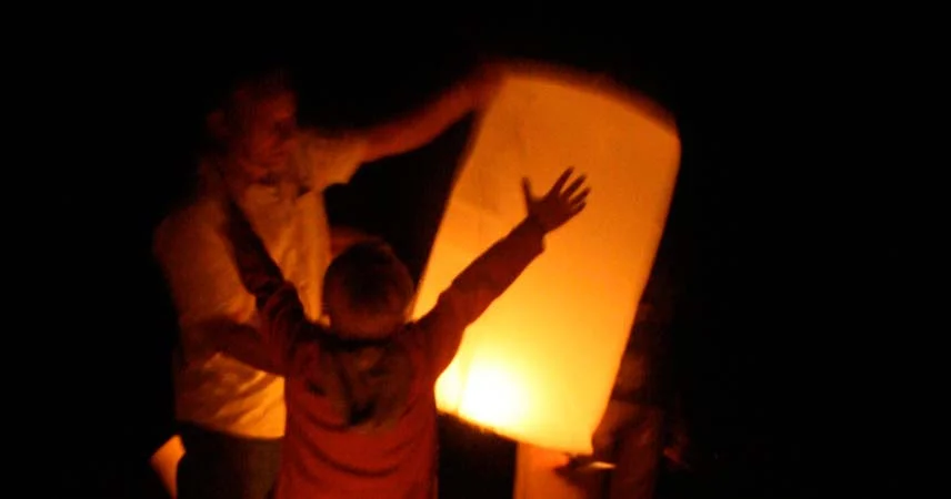 Adult and child holding a large cylinder lantern at Truro City of Lights