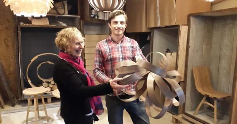 Tom Raffield, a designer, standing with Pat from Bosinver holding decorations.