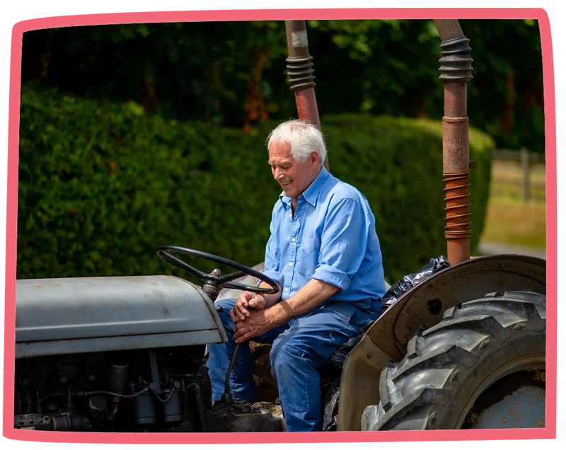 Man driving a tractor on a sunny day at Bosinver.