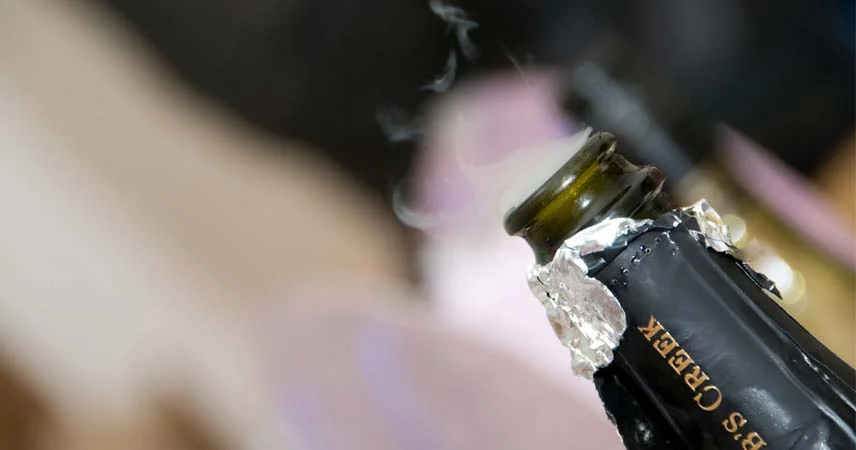 Close up image of a champagne bottle that has just been opened