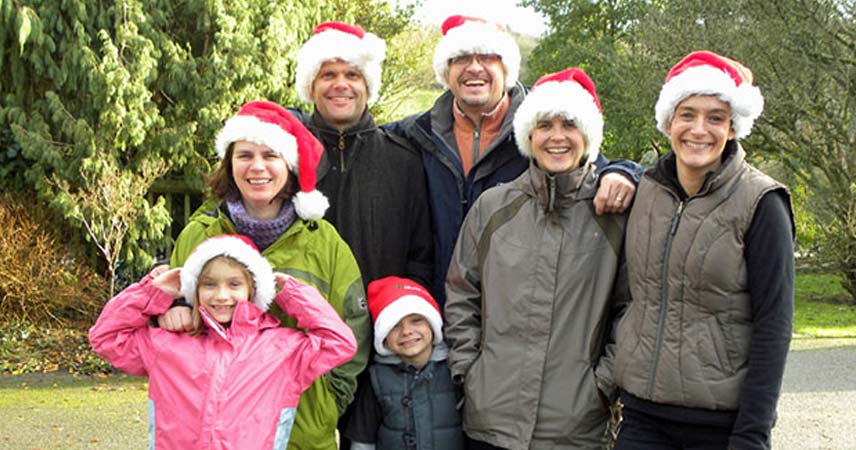 Group shot of a family of six posing for a photo whilst wearing red Santa hats at Bosinver