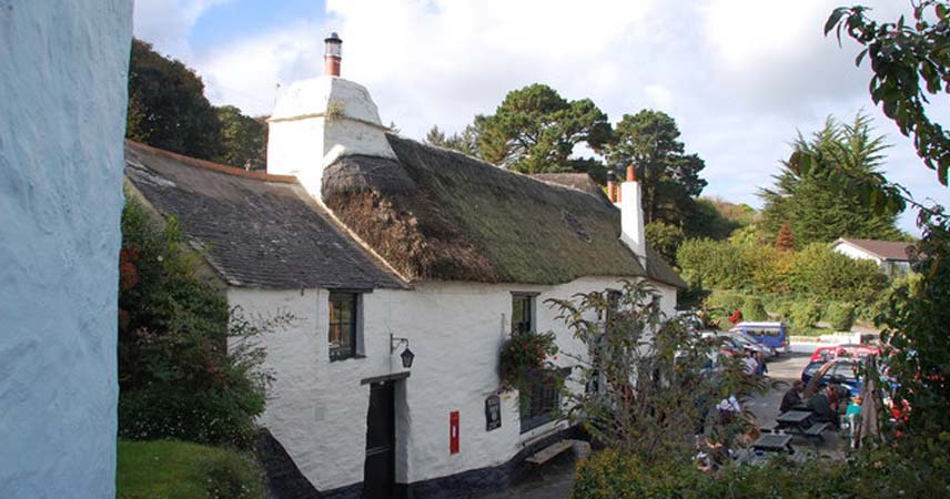 A white thatched cottage in a rural location called the Pandora Inn.