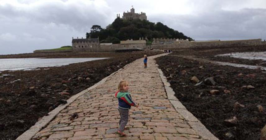 Children walking towards St Micheal's Mount in Cornwall at lowtide