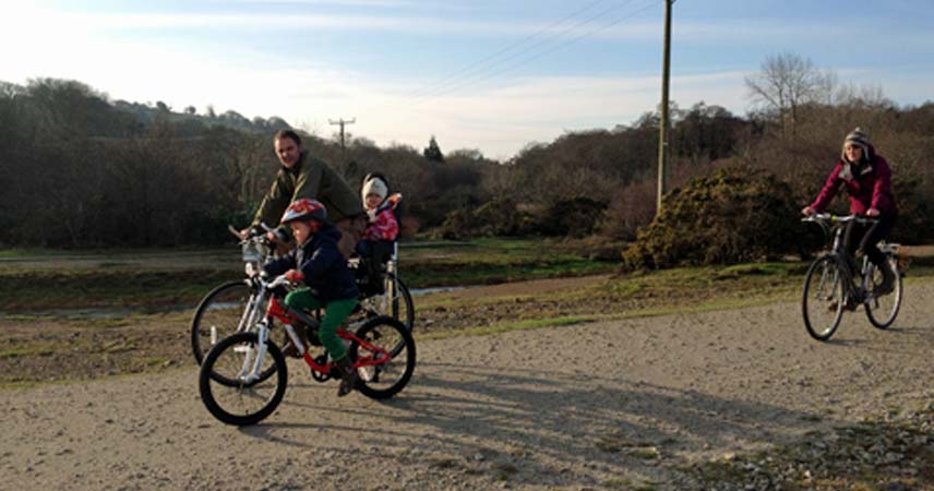 Family of 4 riding bikes along the Bissoe Trail
