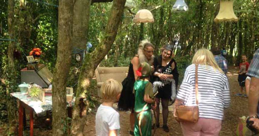 Rogue Theatre interacting with guests at Bosinver in the woodland in Cornwall. Some of the audience are in fancy dress.