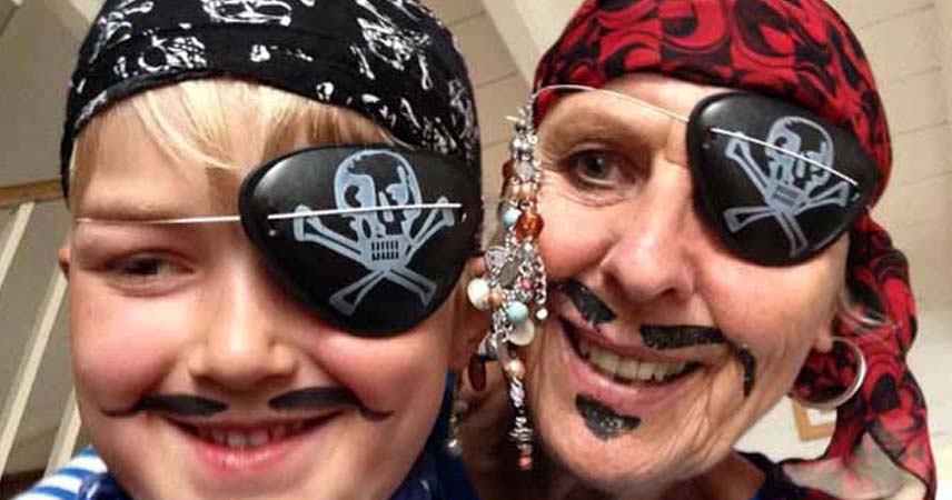 Pat and a child dressed as pirates at Bosinver with head scarves and eye patches.