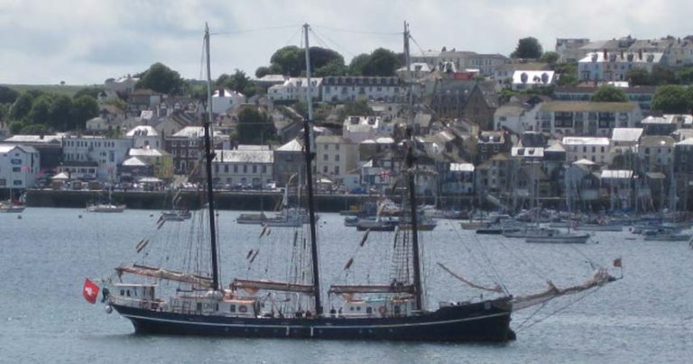 Tall ships in Falmouth, Cornwall, with the town of Falmouth in the background.