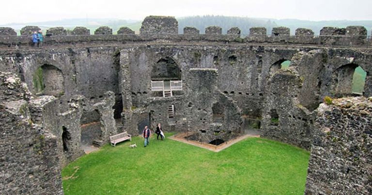 Aerial shot of the inside of Restormel Castle with two adults walking around in the middle of it.