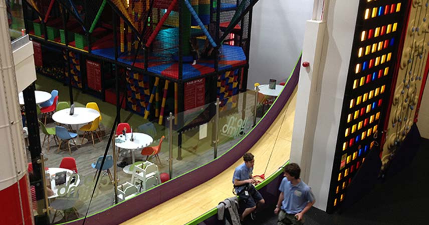 Aerial view of the indoor play area at Cornwall services, showing the soft play area, a seating area and climbing wall.