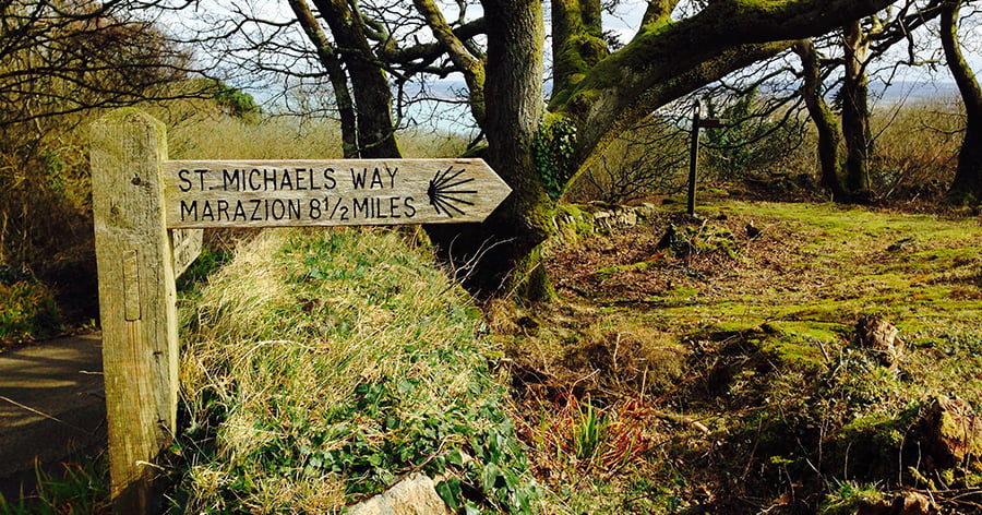 Wooden sign post showing that via St Michael's Way Marazion is eight and a half miles away.