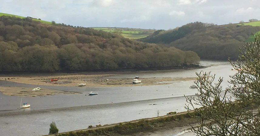 Panoramic view of Saints Way with a few beached boats in the river and between the valleys.