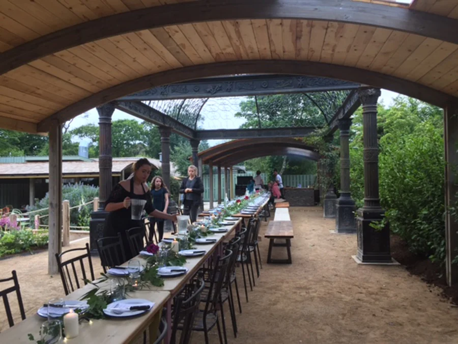 Picture of a long table set ready for guests at the Woodfired Canteen at Heligan Gardens.