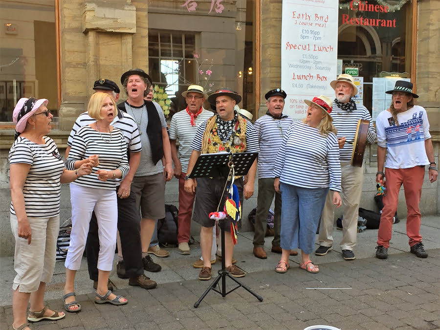 Group of people singing sea shanties in Falmouth, Cornwall.