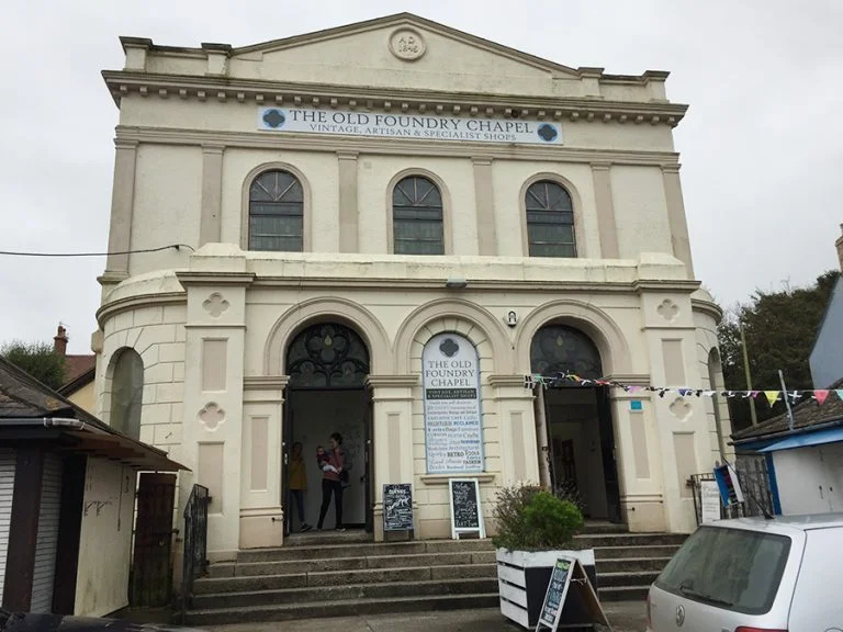 Entrance of the Old Foundry Chapel in Hayle, with a Mother and baby stood in the doorway.