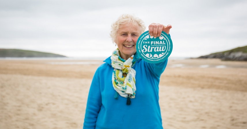 Nanny Pat holidng out The Final Straw logo on a Cornish beach