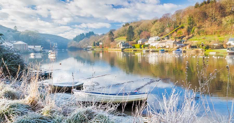 Riverside shot of the winter frost with three grounded rowing boats