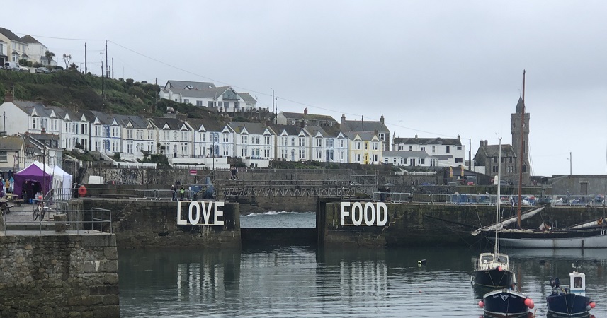 Distance shot of 'Love Food' sign on walls of Porthleven harbour