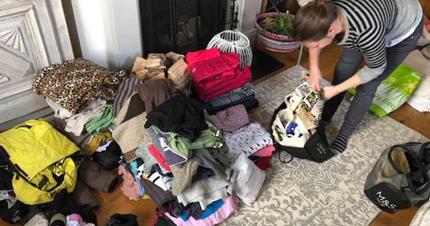 Woman packing stacks of clothing