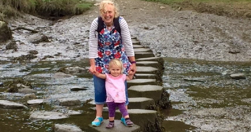 Nanny Pat and young girl standing on stepping stones