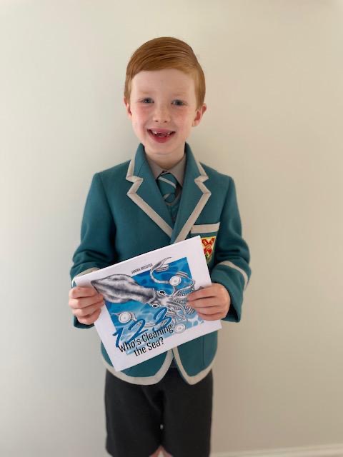 Freddie with his prize from Action Nan: Whos cleaning the sea? by Janina Rossiter