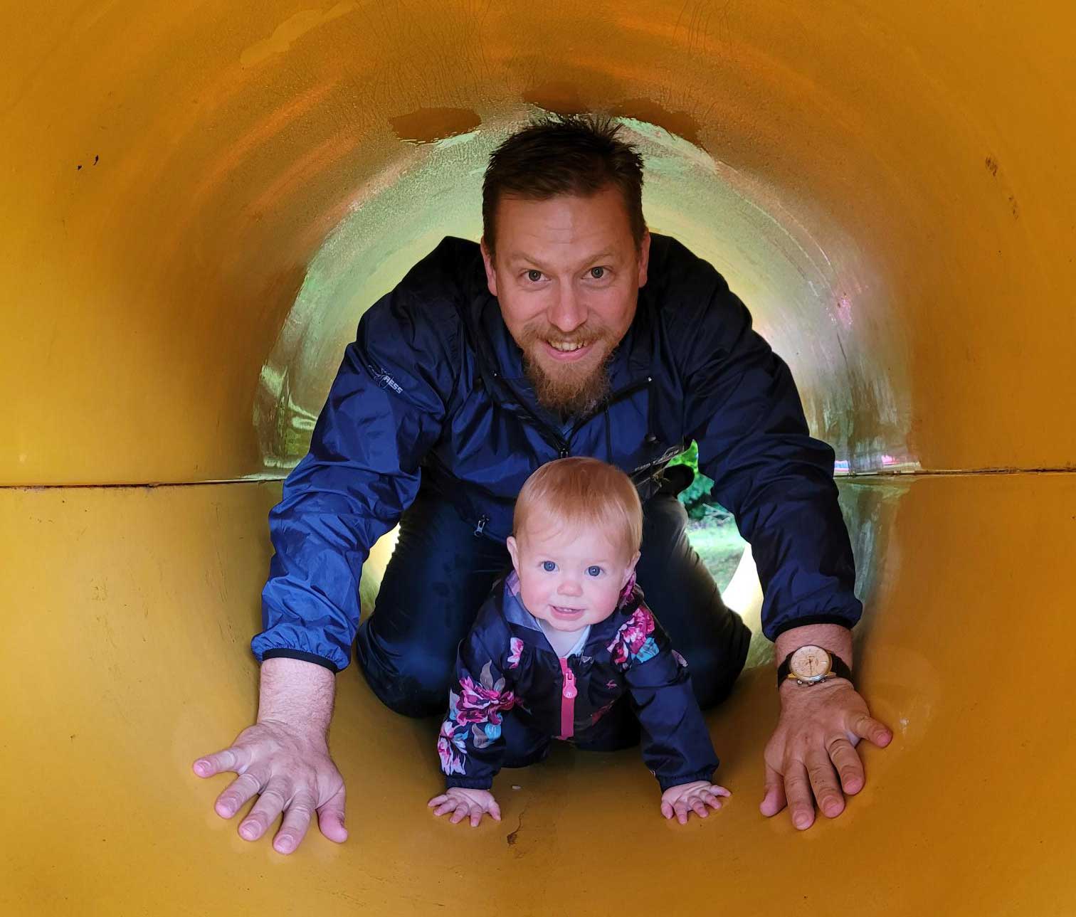 Baby and father in outdoor children's play area