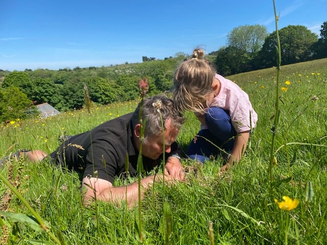 Photo of owner Paul and daughter Jasmine hunting for bugs in a meadow at Bosinver