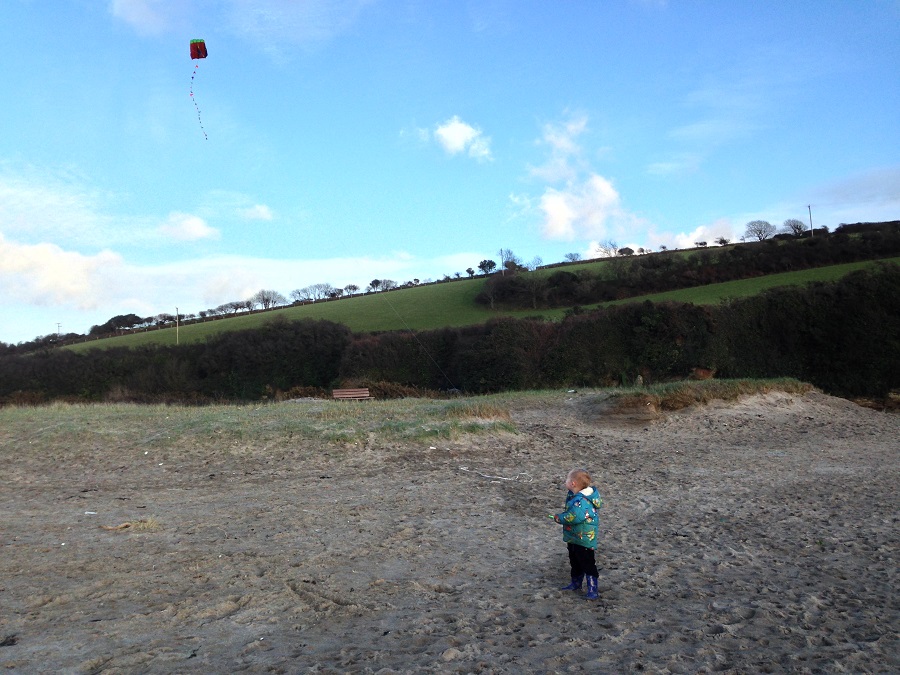 Child flying a kite on the beach