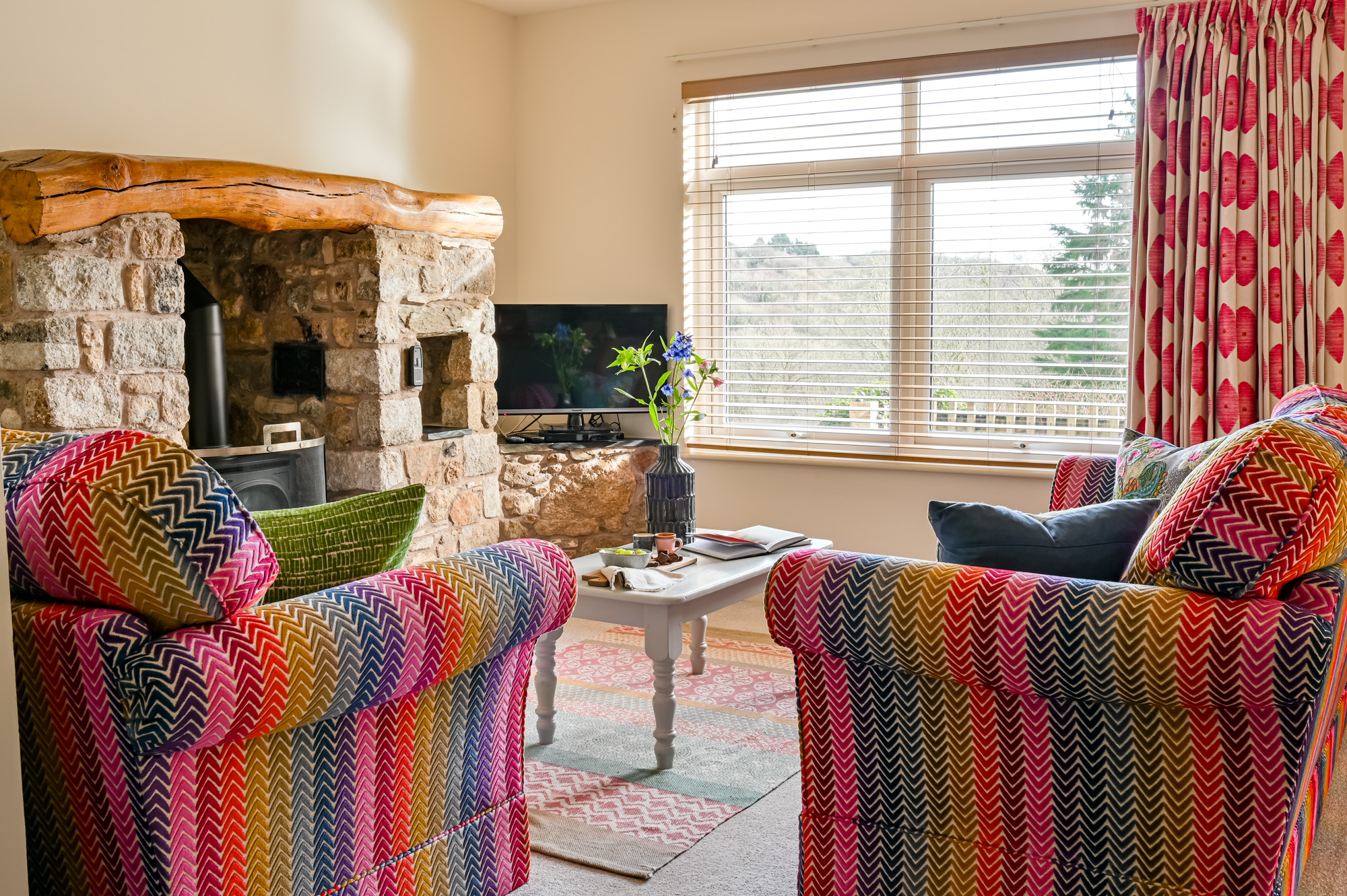 living room showing ends of two sofas, tv, coffee table and fireplace