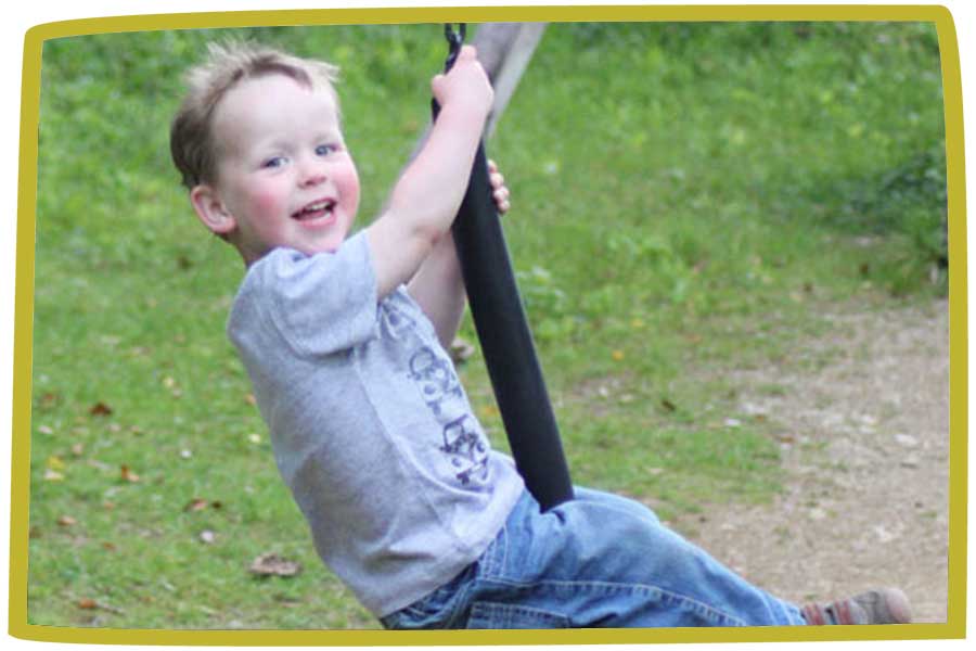 Boy enjoying himself on a tyre swing at bosinver