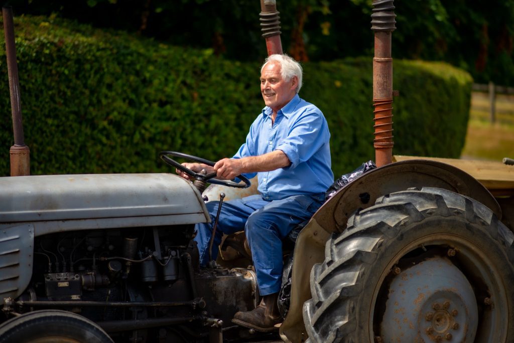 Man driving an old fashioned tractor along a road