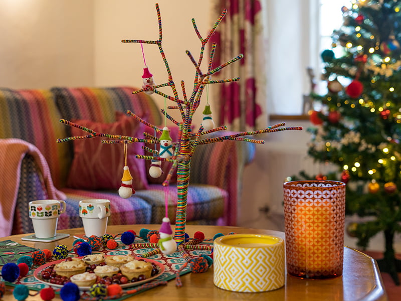 a festive coffee table with novelty tree decoration and a plate of mince pies