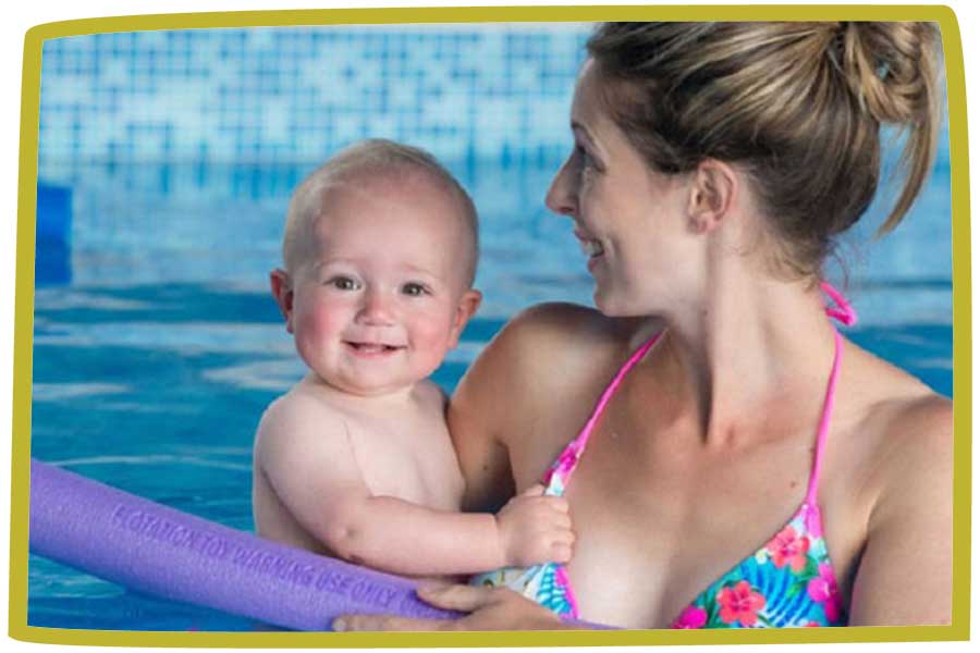 Baby look at the camera as both mother and baby play in a swimming pool.