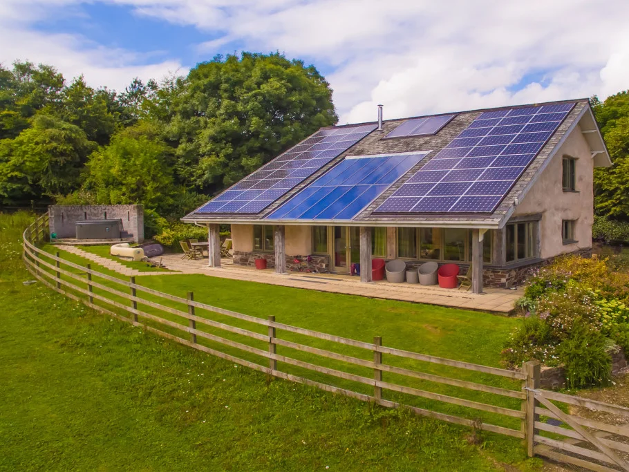 Outside Lowen cottage at Bosinver, its roof is covered in solar panels and a hot tub sits in the corner