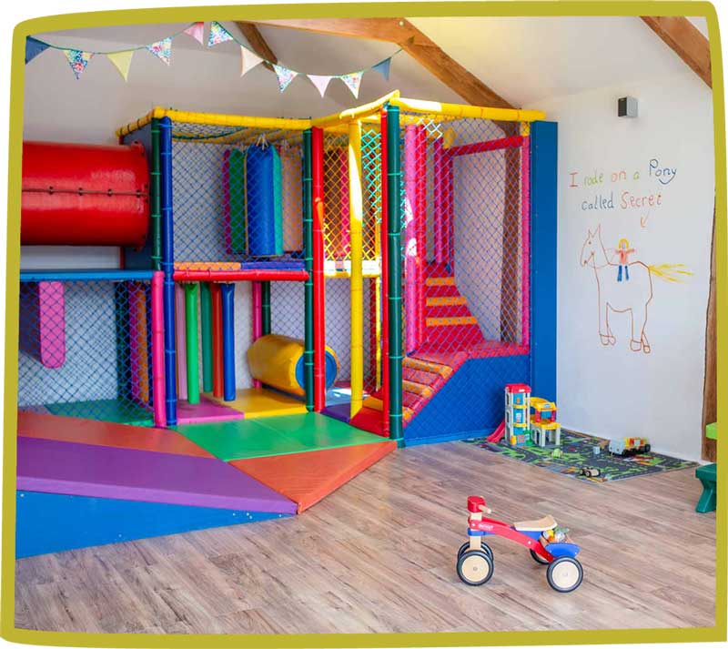 Picture of Bosinver's play room, including indoor play area, tricycle and play mat.