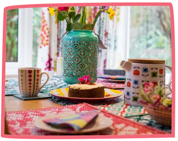 Table set in a cottage at Bosinver with tea and a coffee cake in the middle.