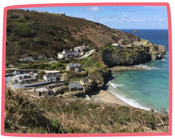 View of a coastal town by a small beach on a sunny day in Cornwall.