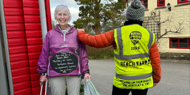 Nanny Pat wearing Beach Clean Bosinver high vis and a cardboard cut out of herself at Bosinver