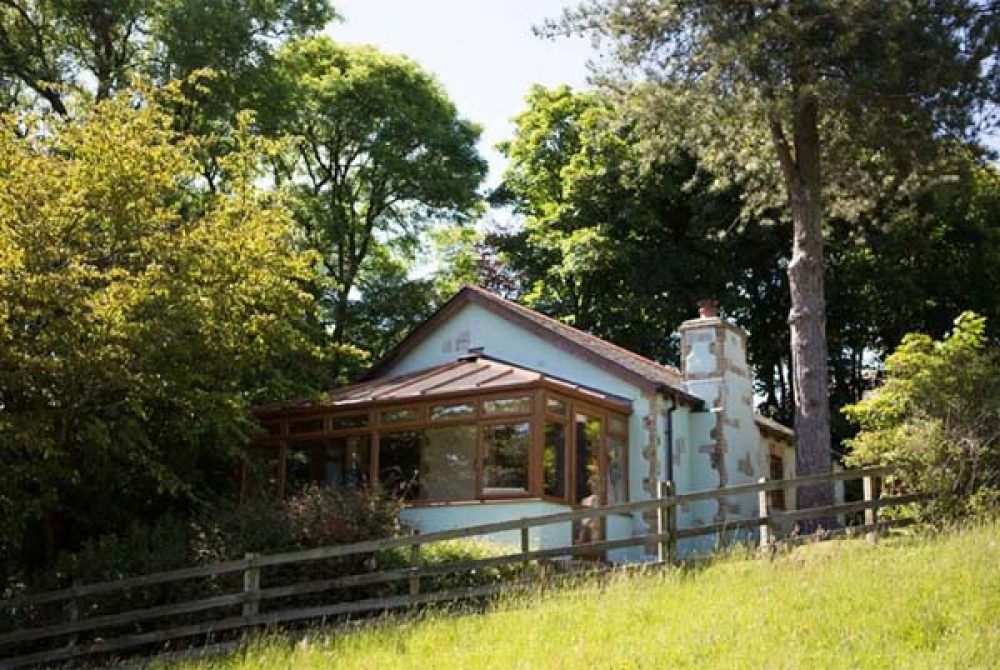 Front shot of Hillside cottage at Bosinver in the trees.